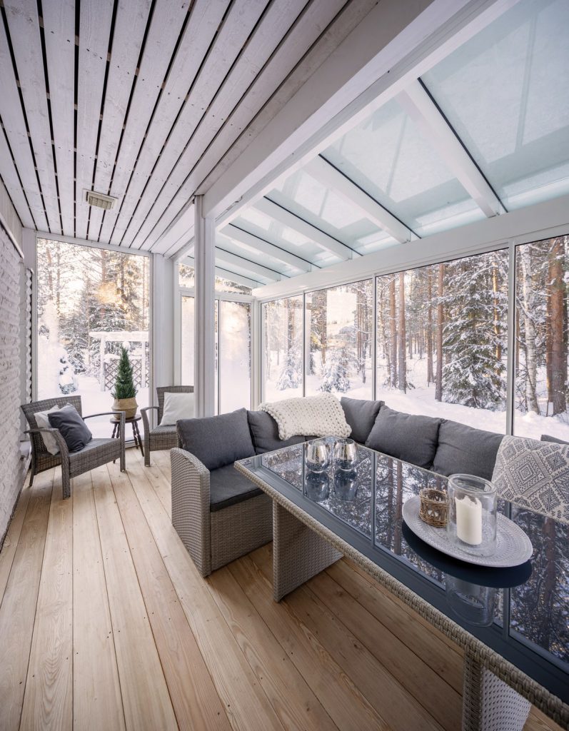 Tällä talvisella terassilla on katon jatkeetan Alutec Vista alumiinirunkoinen lasikatto ja pystypuitteelinen lasitus valkoisilla profiileilla. 